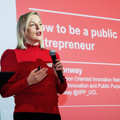 Woman speaker giving talk in front of projector